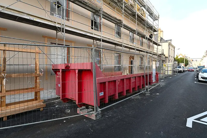 Benne installée le long d’un chantier sur la voie publique