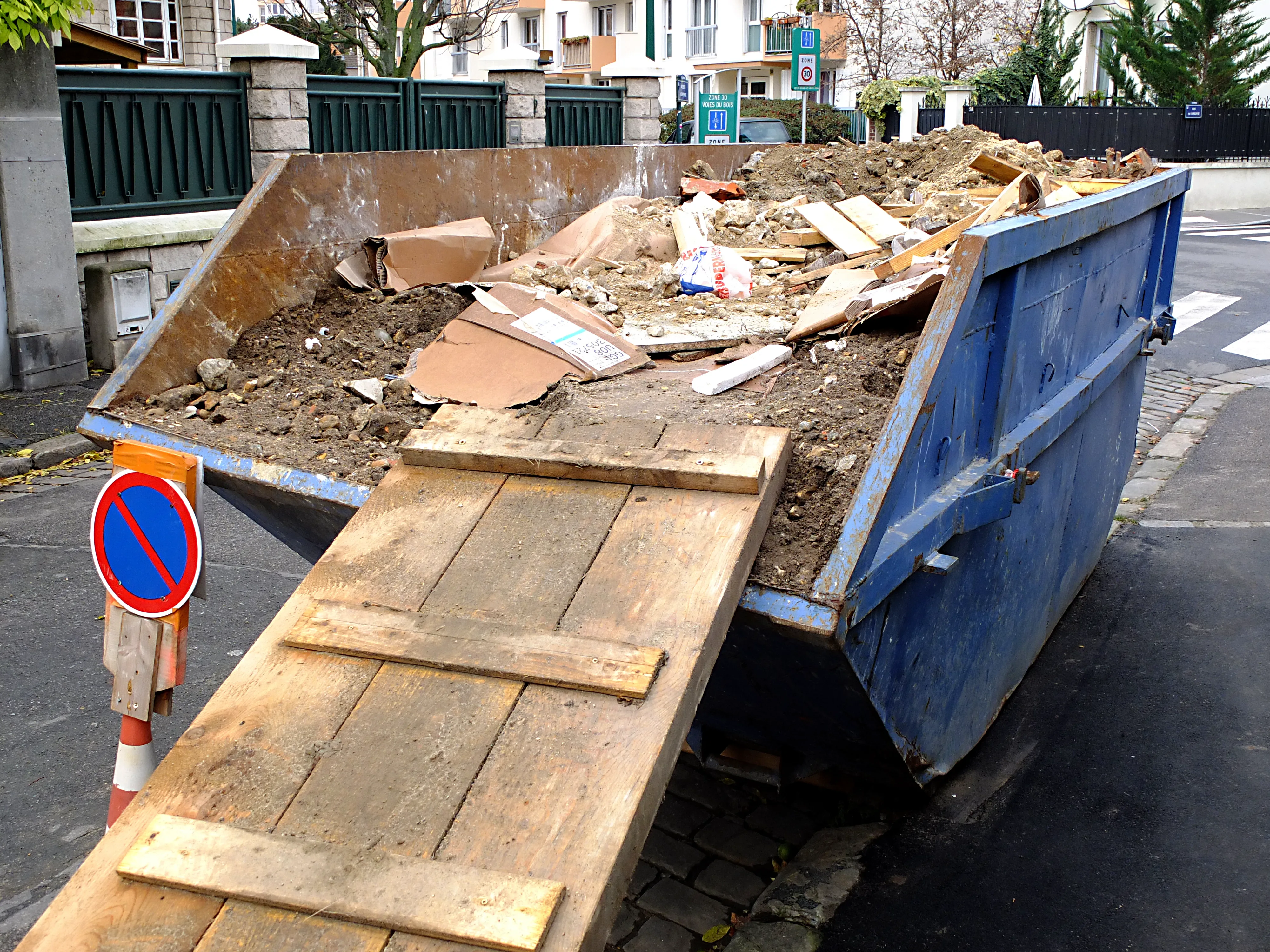 Benne remplie de gravats installée sur la voie publique