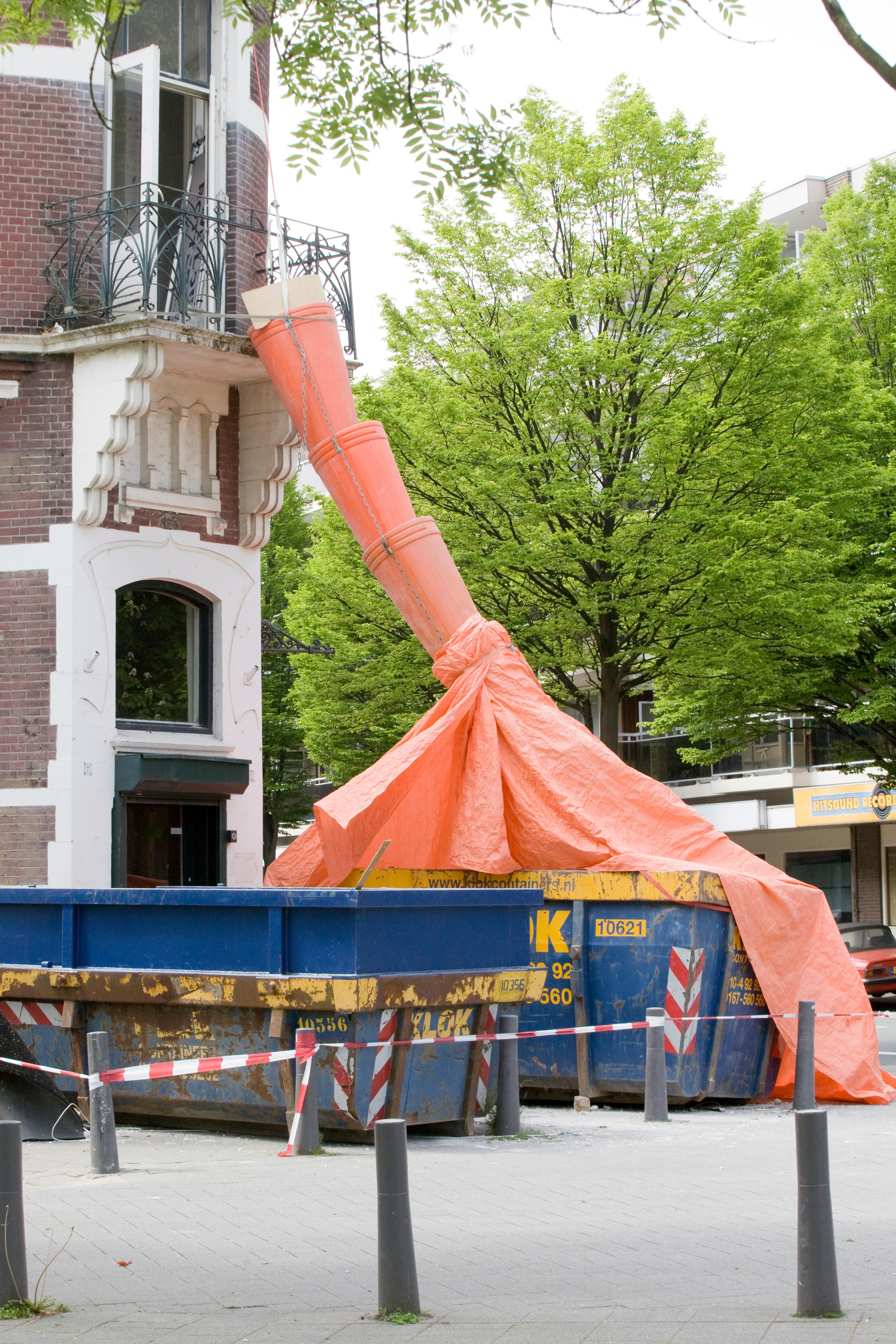 Goulotte à gravats protégée par une bâche au-dessus d’une benne