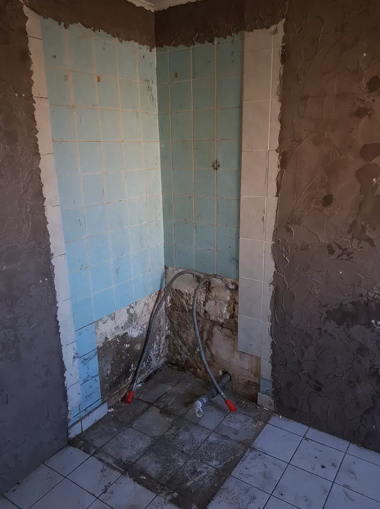 Cabine de douche déposée et salle d’eau partiellement mise à nu