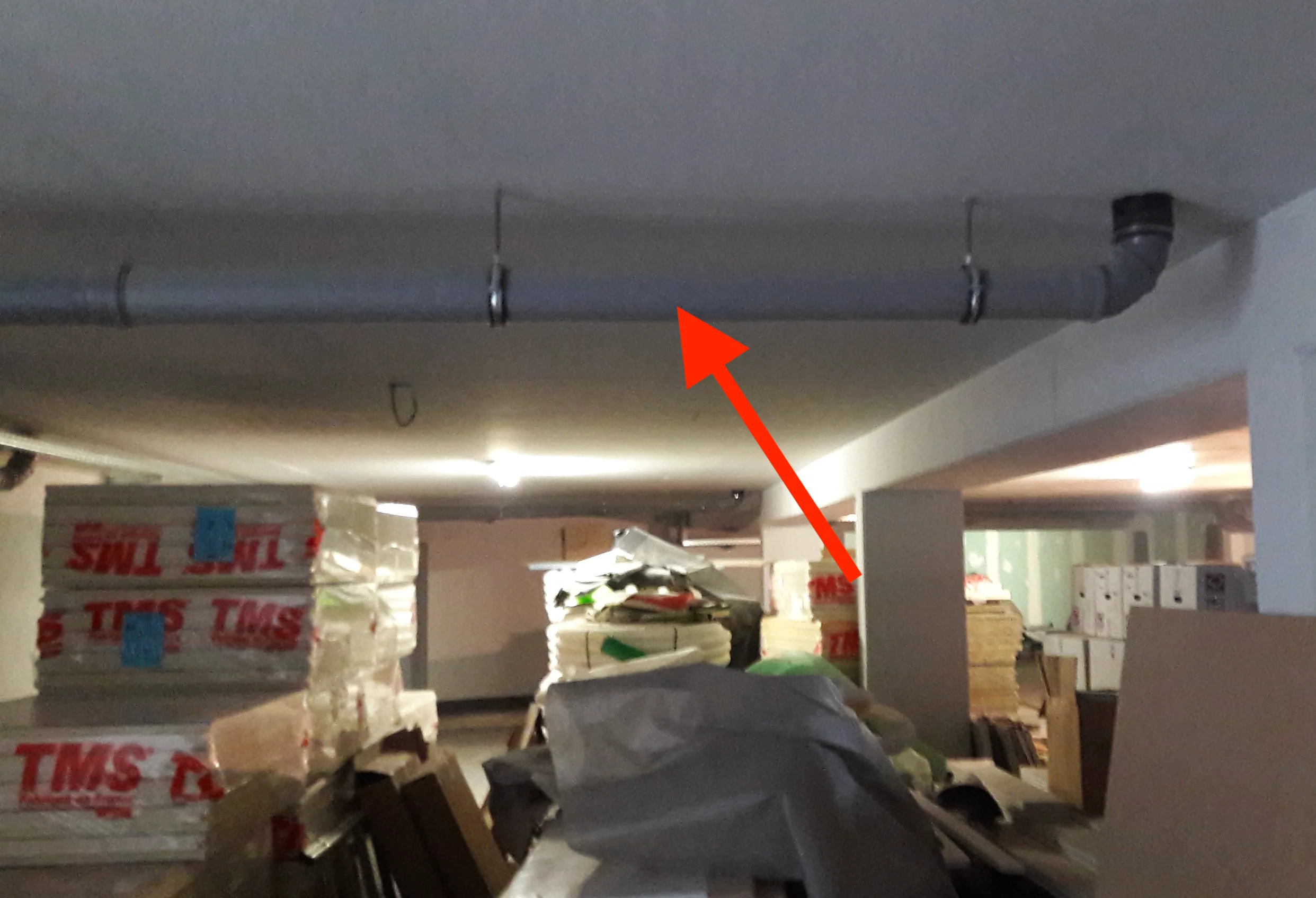 Conduite d’évacuation des eaux usées au plafond d’une cave