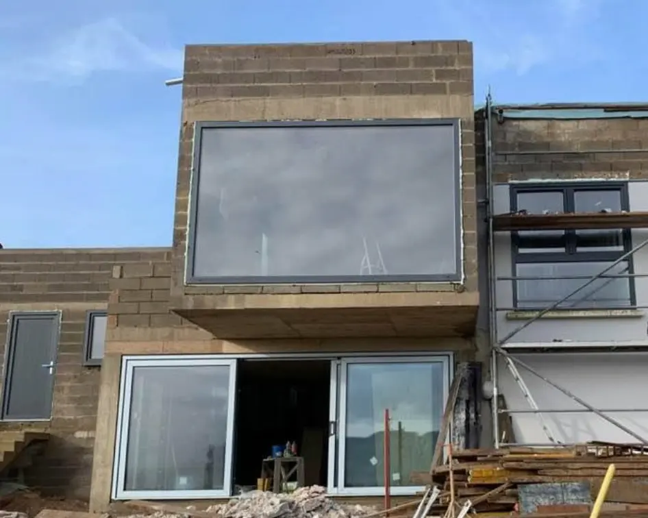 Maison avec baies vitrées en cours de chantier, vue de face