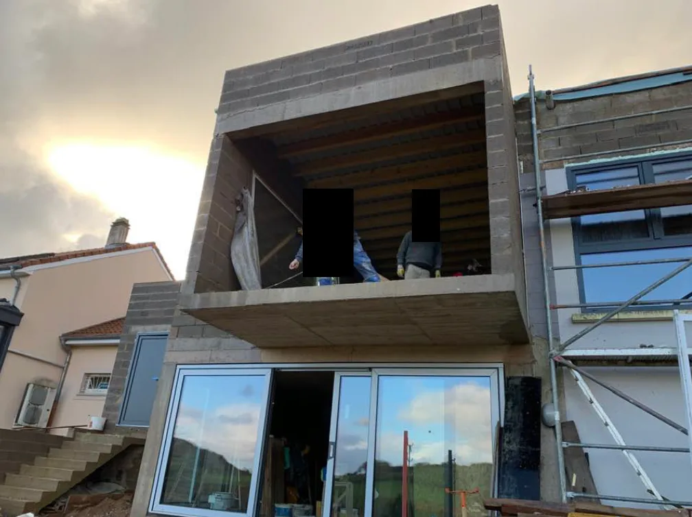 Maison avec baies vitrées en cours de chantier, vue latérale