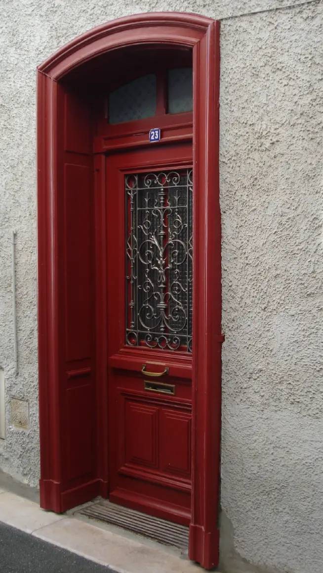 Porte d'entrée ancienne en bois après rénovation et lasure