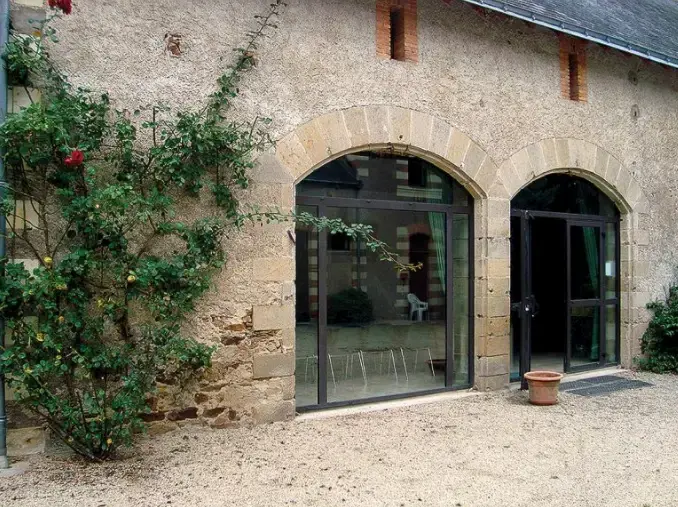 Portes-fenêtres en aluminium dans des baies cintrées en pierre