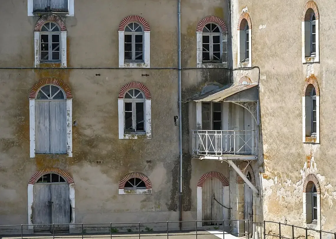 Ancienne façade recouverte d'un enduit ciment gris