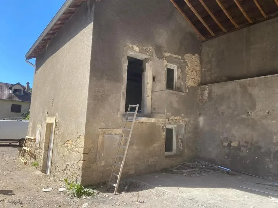 Bâtisse en moellons avant travaux avec enduit ciment soufflé