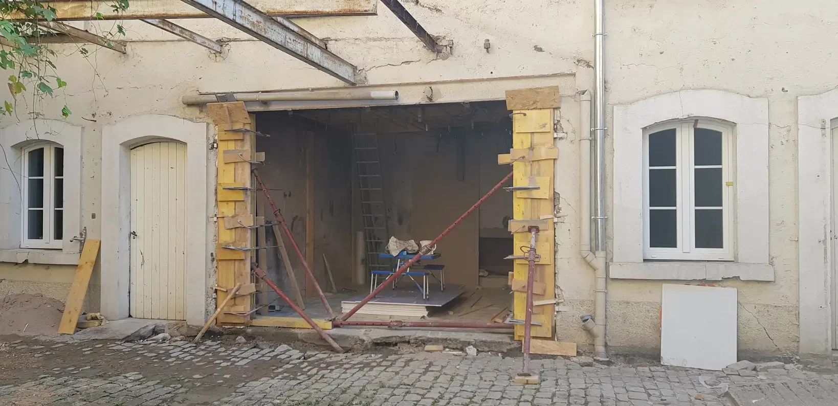 Grande ouverture en cours de création dans la façade ancienne