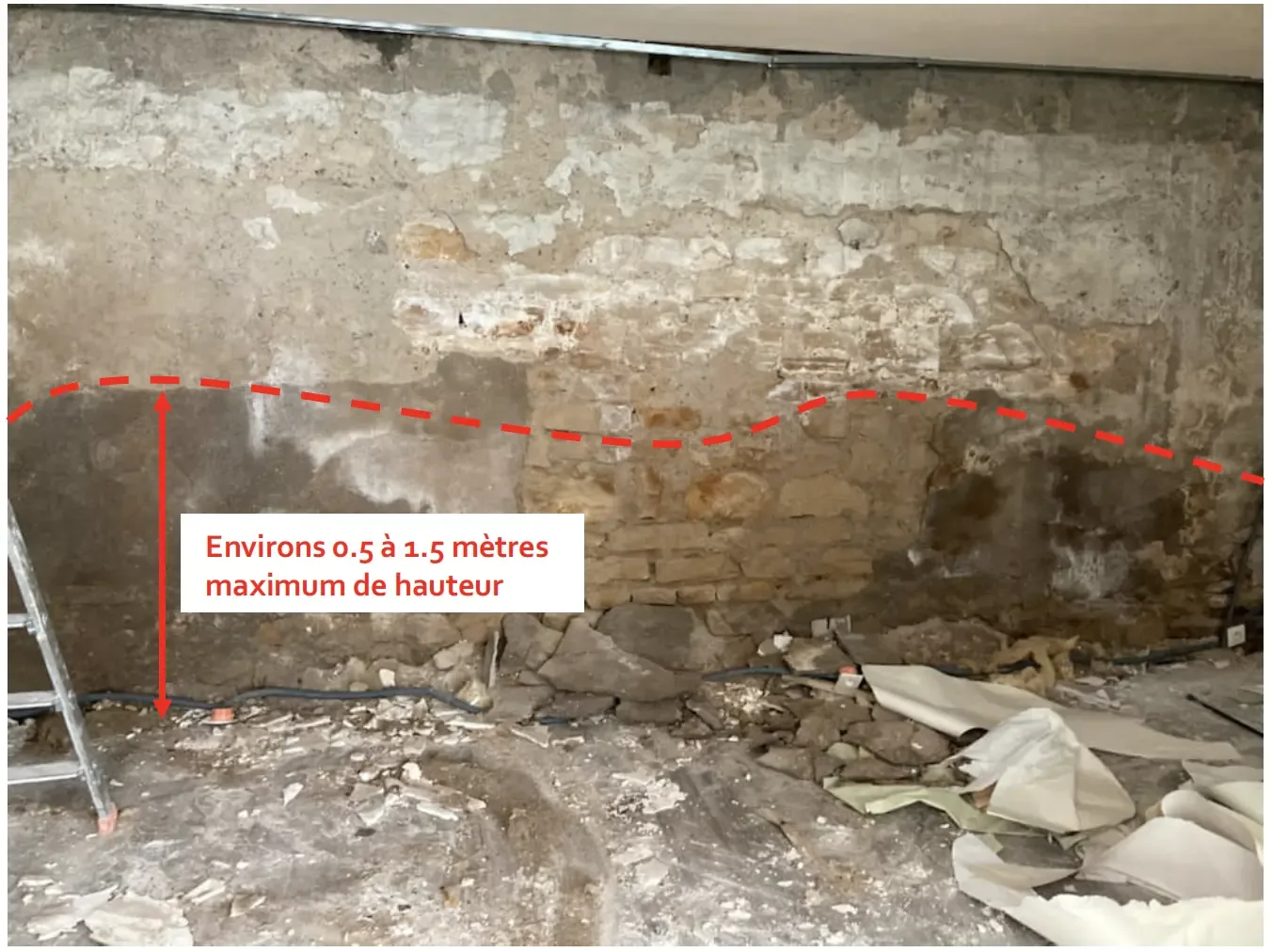 Mur intérieur en pierre humide découvert après la dépose du doublage en placo