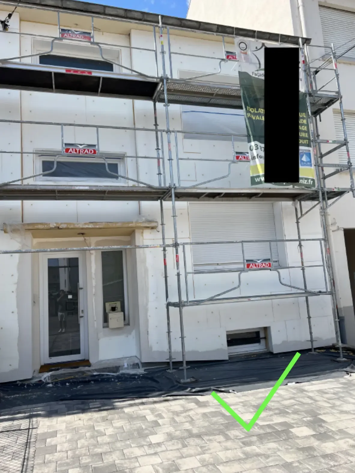 Panneaux isolants blancs chevillés avec retours isolés autour des fenêtres