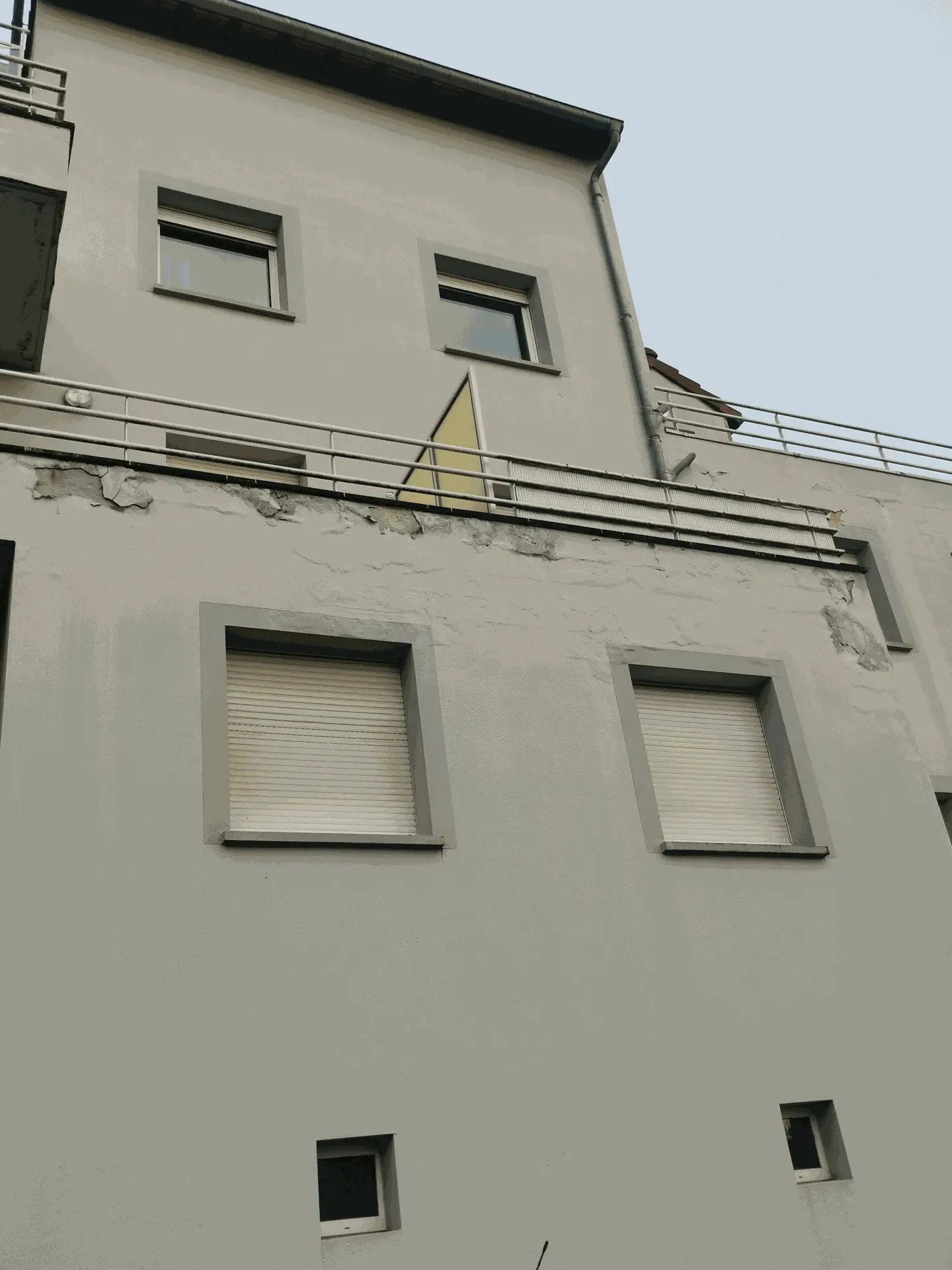Peinture fissurée et écaillée autour de terrasses et fenêtres