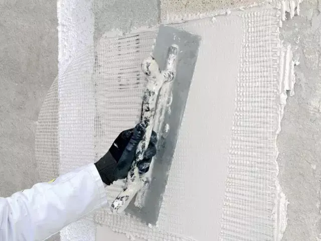 Artisan incorporant une trame anti-fissures dans une sous-couche