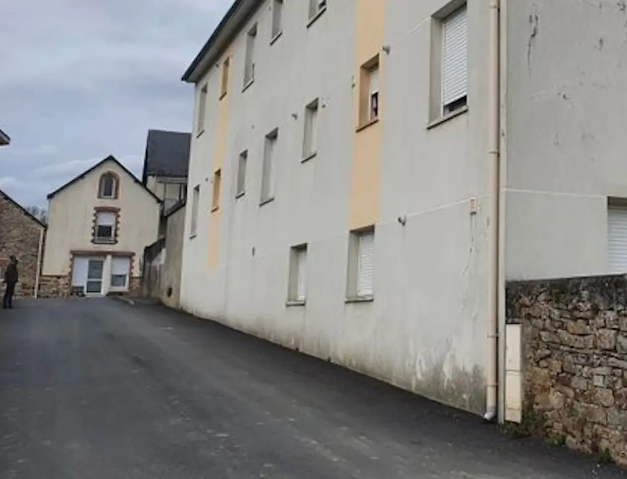 Longue façade tachée et dégradée au pied faute de coupure hydrofuge